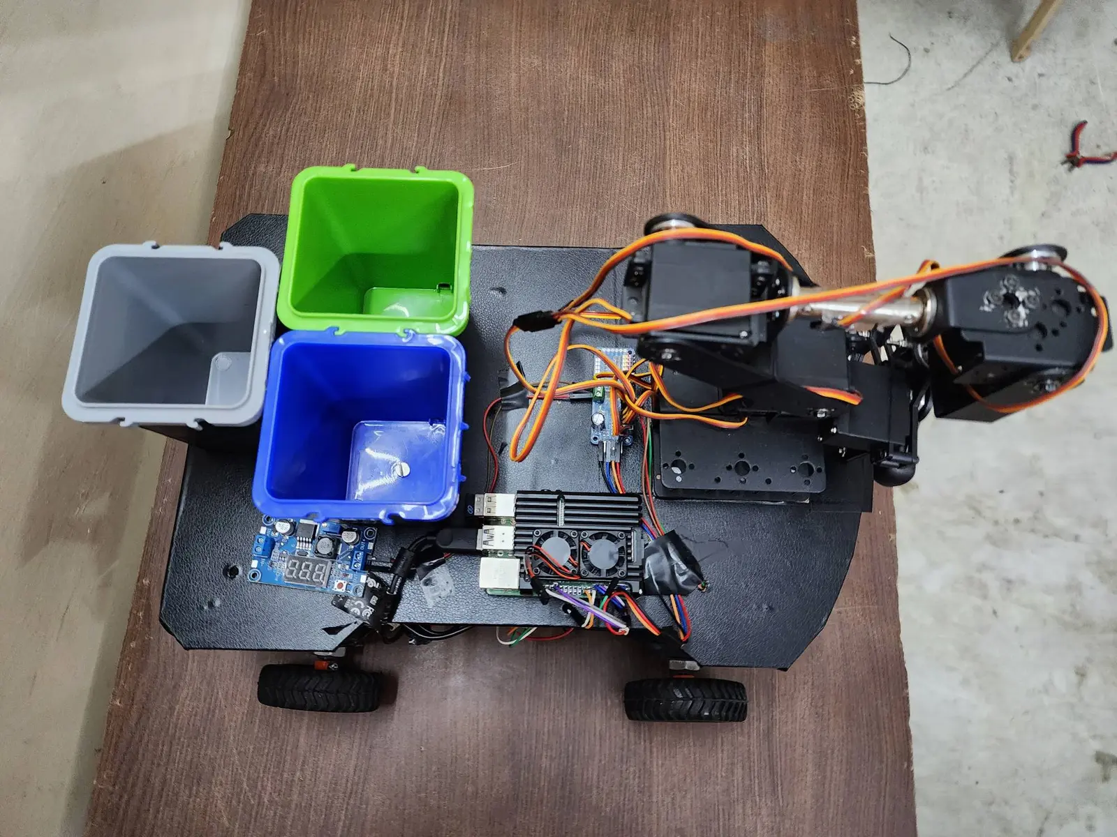 EIRT robot by Oluwaferanmi Iyiola, seen from above: Raspberry Pi, servo driver, arm, bins and power regulator