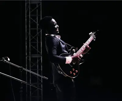 Playing electric guitar on stage · iyiolastrings, Oluwaferanmi Iyiola